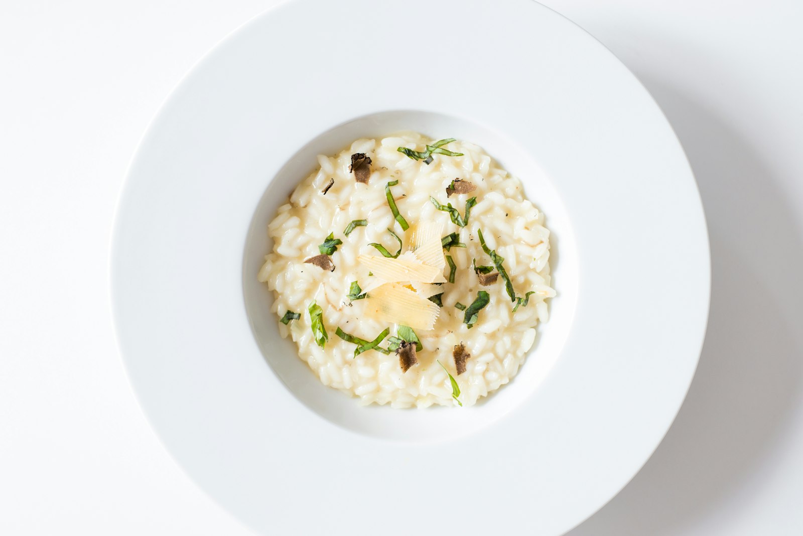 Bowl of creamy mushroom risotto topped with grated Parmesan and thyme