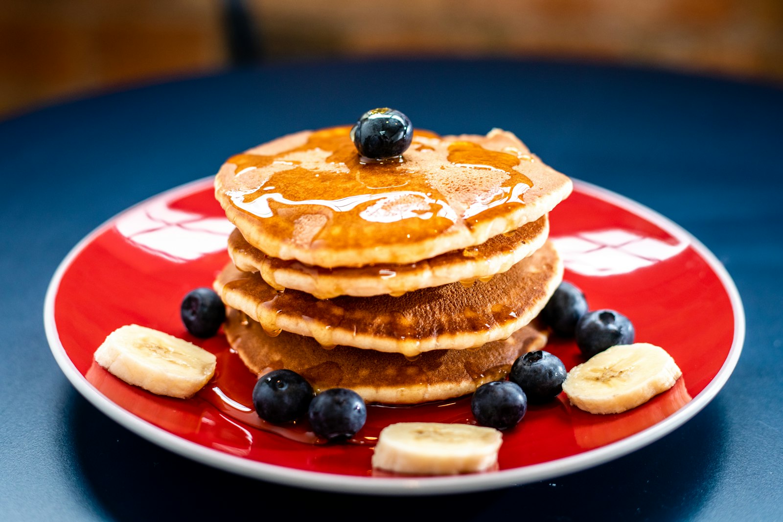 Stack of golden buttermilk pancakes with melting butter and maple syrup